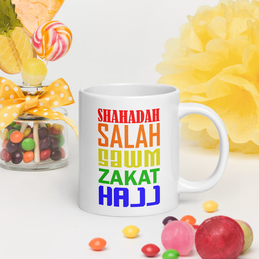 A mug displaying the words of the 5 pillars of islam in a variety of colours.
